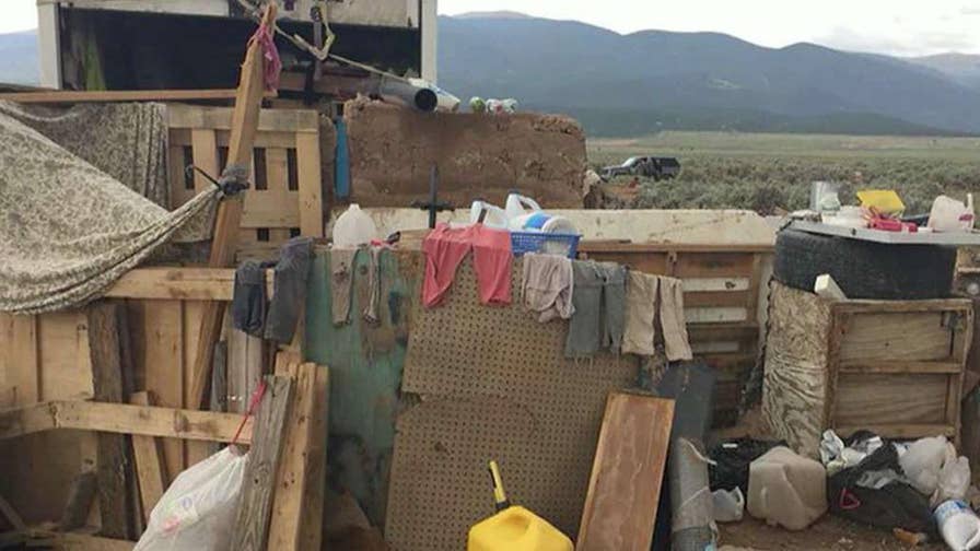 11 children rescued from heavily-armed compound built out of garbage.