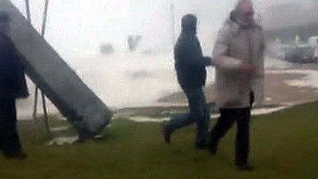 Wipe out: Spectators scatter when massive wave jumps seawall