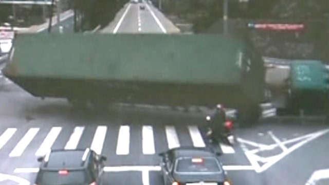 Close call: Motorcyclist nearly crushed by overturned truck