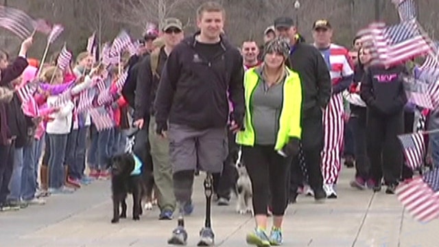 Hero who saluted from hospital bed walks across finish line
