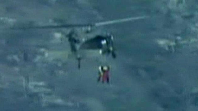 Rescuers rappel from helicopter to save climber
