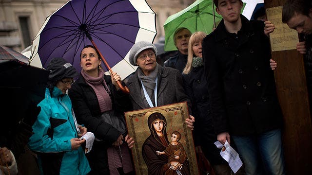 Faithful await word of new pope from wet St. Peter's Square