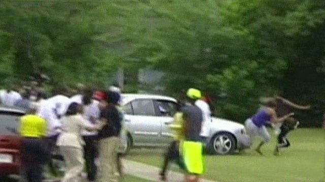 Wild scene as murder suspect's dad crashes car through crowd
