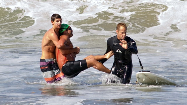 Shark bites swimmer while fighting fisherman's hook