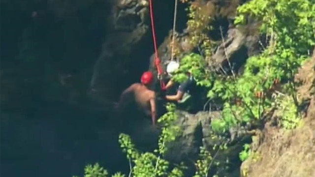 Crews try to rescue man who slid underneath bridge in Wash.