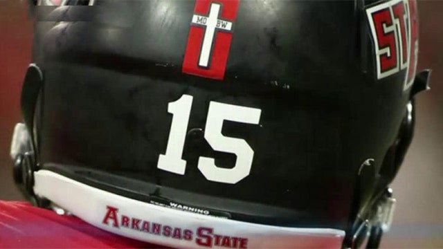 College football team forced to removed cross from helmets