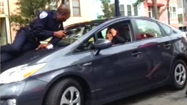 Reckless driver flees with parking officer on hood of car