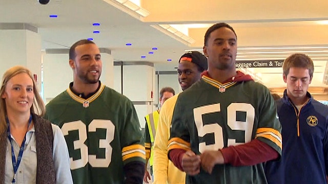 Green Bay Packers football players work at airport