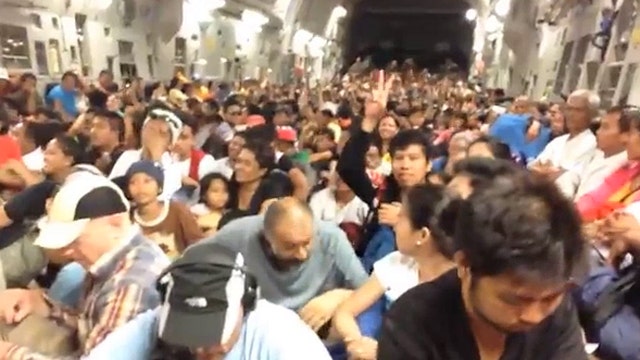 Typhoon survivors cheer after landing in Manila