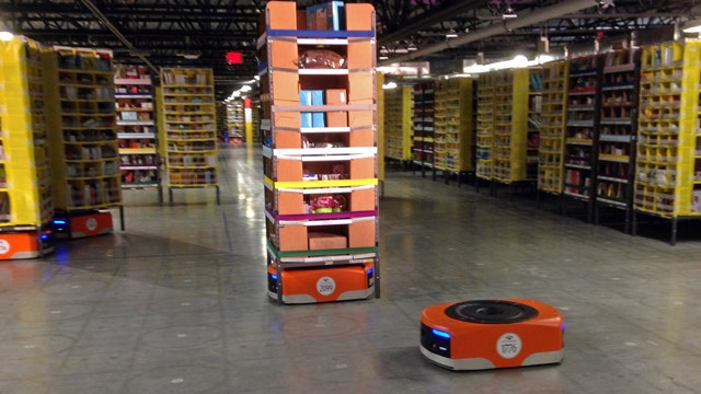 Amazon robots help deliver stacks of products to workers