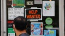 FILE PHOTO: A pedestrian passes a &quot;Help Wanted&quot; sign in the door of a hardware store in Cambridge, Massachusetts, U.S., July 8, 2022.   REUTERS/Brian Snyder