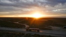 The sun rises behind an oil tanker driving through the Permian Basin in Mentone, Texas, on Nov. 26, 2019.