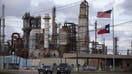 An American and Texas flag stand in front of the Chevron Corp. Pasadena Refinery in Pasadena, Texas, U.S., on Sunday, March 8, 2020. Houston has been purposefully going green for more than a decade. The municipal government gets 92% of all the power it uses in the buildings it owns from wind and solar and has been on the U.S. Environmental Protection Agencys list of the largest renewable power users since 2016. 