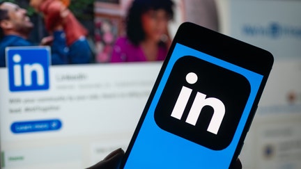 LinkedIn logo displayed on a smartphone with LinkedIn web page seen in the background, in this photo illustration. On 16 October 2023, in Brussels, Belgium. (Photo by Jonathan Raa/NurPhoto via Getty Images)
