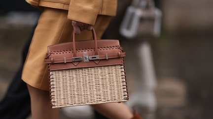 PARIS, FRANCE - MARCH 02: Fashion Week Guest seen wearing a brown leather coat, brown boots and Hermes Birkin picnic bag outside Hermes show, during the Womenswear Fall/Winter 2024/2025 as part of Paris Fashion Week on March 02, 2024 in Paris, France. (Photo by Jeremy Moeller/Getty Images)
