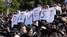 Student graduates hold white t-shirts stating the message, &quot;divest,&quot; as they protest during the UC Berkeley graduation held at California Memorial Stadium following weeks of pro-Palestinian protests in Berkeley, Calif. on Saturday, May 11, 2024.