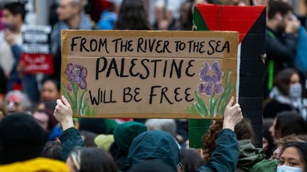 A pro-Palestinian activist holds up a sign reading 'From The River To The Sea Palestine Will Be Free' during a sit-down protest inside Charing Cross railway station to call for an immediate ceasefire in Gaza on 4th November 2023 in London, United Kingdom. Mass Palestinian solidarity rallies have been held throughout the UK for a fourth consecutive weekend to call for an end to the Israeli bombardment of Gaza. (photo by Mark Kerrison/In Pictures via Getty Images)
