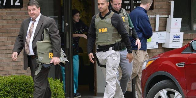 FBI agents leave the office of Dr. Fakhruddin Attar at the Burhani Clinic in Livonia, Mich., after completing a search for documents, April 21, 2017. The investigation was connected to the case of Dr. Jumana Nagarwala, who was charged with performing genital mutilation on two young girls from Minnesota. (Detroit News via AP)