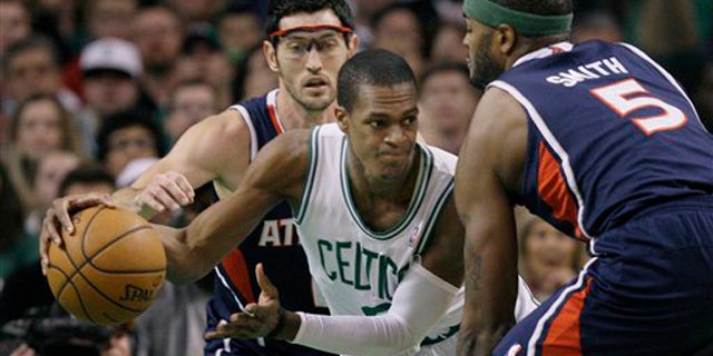 April 11, 2012: Boston Celtics guard Rajon Rondo (9) looks to pass against the double-team by Atlanta Hawks guard Kirk Hinrich and forward Josh Smith (5) during the first half of an NBA basketball game in Boston.