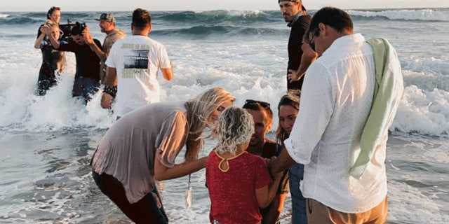 People get baptized at the Saturate OC event July 10, on Huntington Beach, Calif.