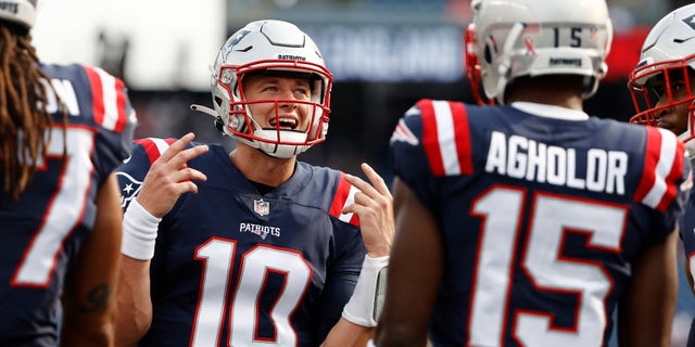 New England Patriots quarterback Mac Jones (10) walks with teammates prior to an NFL football game against the Miami Dolphins, Sunday, Sept. 12, 2021, in Foxborough, Massachusetts.