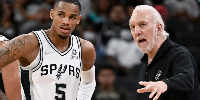 San Antonio Spurs head coach Gregg Popovich, right, talks with Spurs guard Dejounte Murray during the second half of a preseason NBA basketball game against the Miami Heat, Friday, Oct. 8, 2021, in San Antonio. (AP Photo/Darren Abate)