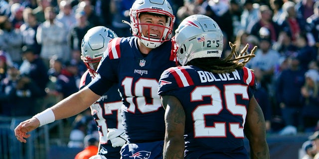 New England Patriots running back Brandon Bolden (25) celebrates with quarterback Mac Jones (10) after his touchdown during the first half of an NFL football game against the New York Jets, Sunday, Oct. 24, 2021, in Foxborough, Massachusetts.