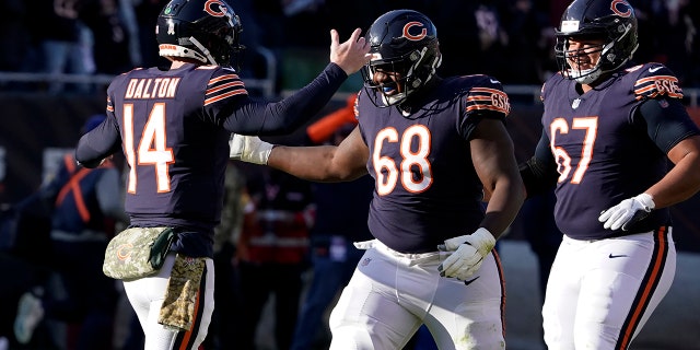 Chicago Bears quarterback Andy Dalton (14) celebrates his touchdown pass tp Darnell Mooney with James Daniels (68) and Sam Mustipher during the second half of an NFL football game against the Baltimore Ravens Sunday, Nov. 21, 2021, in Chicago.