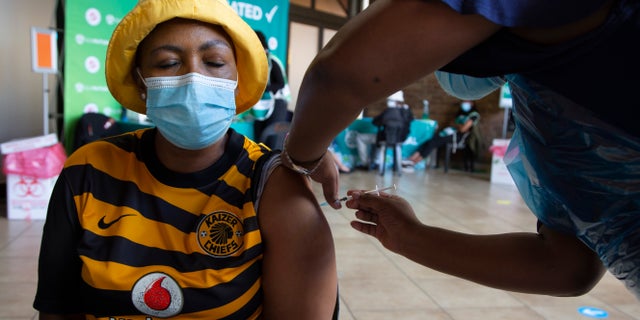 A woman receives a COVID-19 vaccine at a facility in Soweto, South Africa, Wednesday Dec. 2, 2021. South Africa has accelerated its vaccination campaign by giving jabs at pop-up sites in shopping centers and transport hubs to combat the rapidly rising new cases of COVID-19. (AP Photo/Denis Farrell)