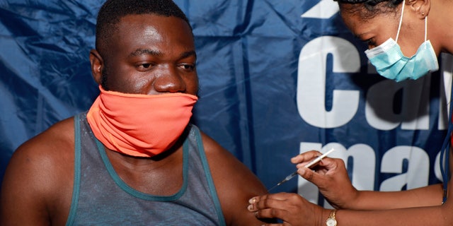 Noesqui Muanza, 33, receives a dose of the Pfizer COVID-19 vaccine at the Vaccination Centre of Hope at the Cape Town International Convention Centre in Cape Town, South Africa, Friday, Dec. 3, 2021. The mass Covid-19 vaccination site is closing today after vaccinating more than 136 000 people at the Western Cape's first mass vaccination centre. (AP Photo/Nardus Engelbrecht)
