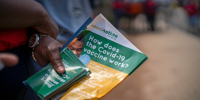 Volunteers go door to door with vaccination information material in Lawley, South Africa, during a visit of local government officials for the launch of the Vooma vaccination program against COVID-19 Friday Dec. 3, 2021. South Africa has accelerated its vaccination campaign a week after the discovery of the omicron variant of the coronavirus. (AP Photo/Jerome Delay)