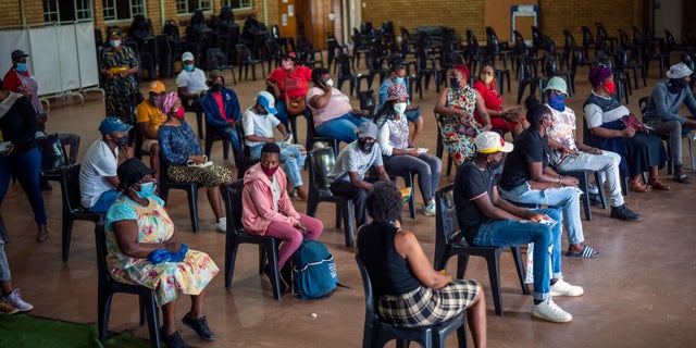 People who have just received their jab against COVID-19 Friday Dec. 3, 2021 wait for their vaccine card to be processed at the Orange Farm, South Africa, multipurpose center. South Africa has accelerated its vaccination campaign a week after the discovery of the omicron variant of the coronavirus. (AP Photo/Jerome Delay)