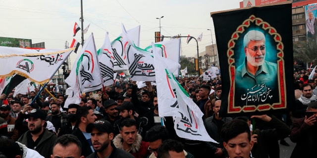 1 Ocak 2022 Cumartesi günü Bağdat, Irak'ta Halk Seferberlik Güçleri destekçileri ve üyeleri sloganlar atıyor.