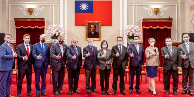 In this photo released by the Taiwan Presidential Office, members of an American Congressional delegation, from left, Rep. Ronny Jackson, R-Texas, Sen. Ben Sasse, R-Neb., Sen. Rob Portman, R-Ohio, Sen. Richard Burr, R.N.C., Sen. Bob Menendez, DN.J., and Sen. Lindsey Graham, RS.C., pose for a photo with Taiwan's President Tsai Ing-wen, center right, and other Taiwanese officials during a meeting at the Presidential Office in Taipei, Taiwan, Friday, April 15, 2022.