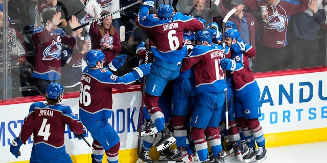 Colorado Avalanche defenseman Cale Makar is swarmed by teammates after scoring against the Nashville Predators during overtime in Game 2 of an NHL hockey Stanley Cup first-round playoff series Thursday, May 5, 2022, in Denver. The Avalanche won 2-1.