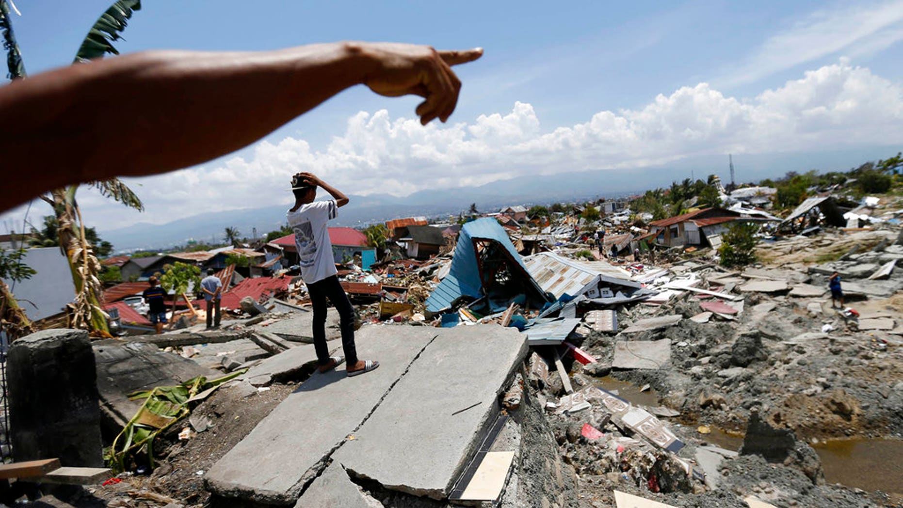 FILE: Indonesian men survey the damage in Balaroa neighborhood in Palu, Central Sulawesi, Indonesia.