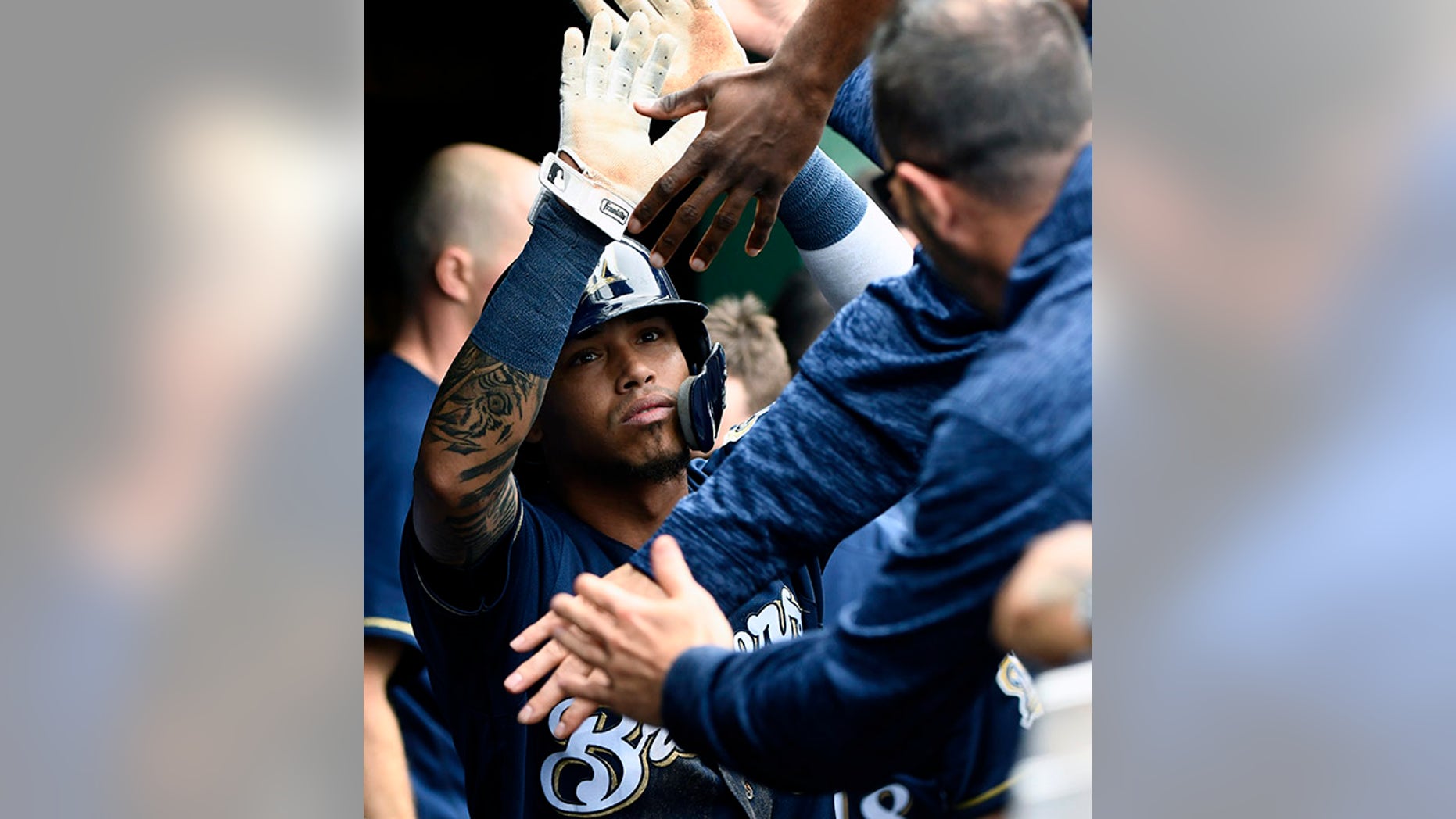 Milwaukee Brewers' Orlando Arcia (3) celebrates in the dugout after scoring during the third inning of a tiebreak baseball game against the Chicago Cubs on Monday, Oct. 1, 2018, in Chicago. (AP Photo/Matt Marton)