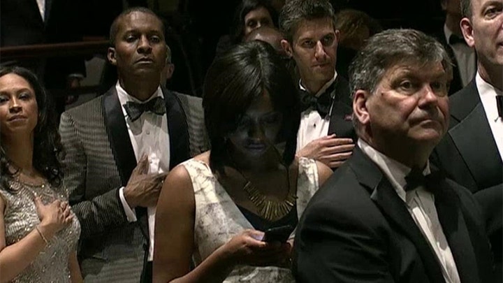 Reporter glued to her phone during the National Anthem