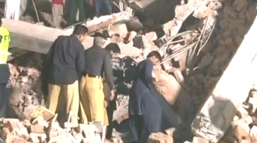 Rescuers search rubble for survivors of building collapse