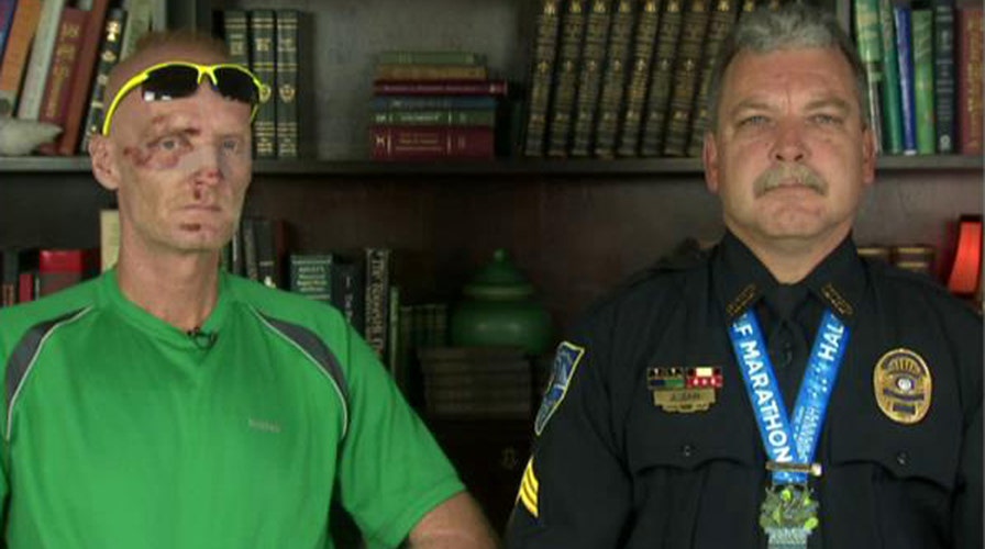 Officer helps fallen runner across the finish line