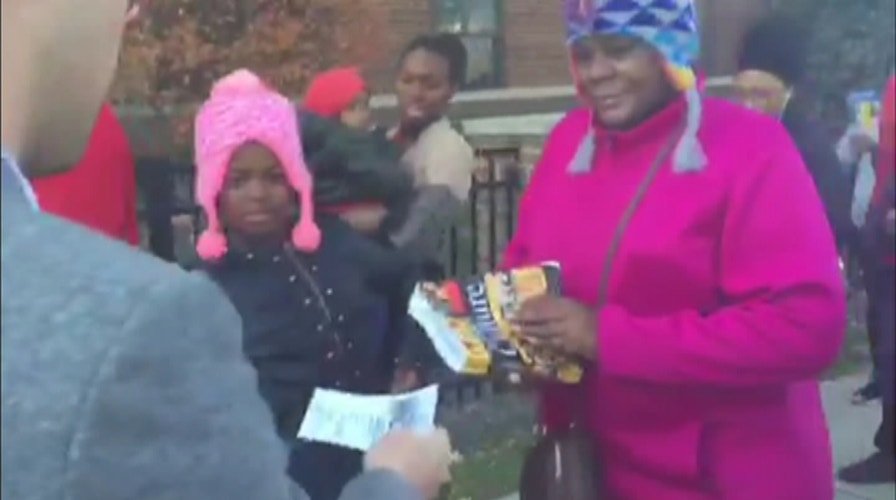 Man hands out Clinton-LeBron event fliers at polling station