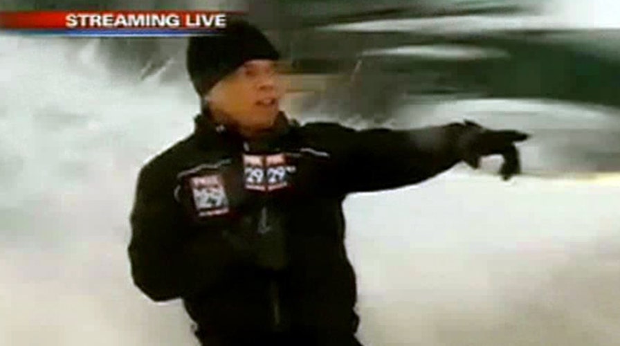 Unsuspecting reporter snowed under by passing plow