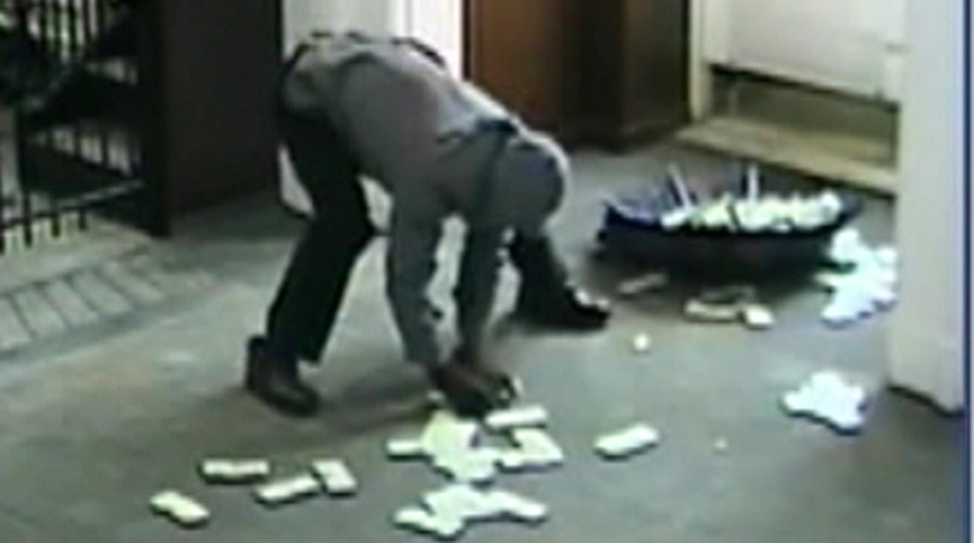 Bumbling bank robber without bag uses umbrella to carry cash