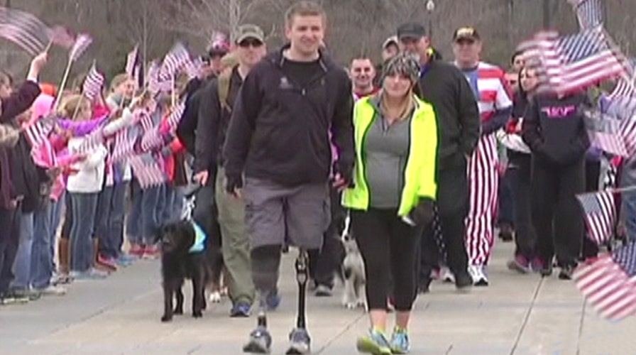 Hero who saluted from hospital bed walks across finish line