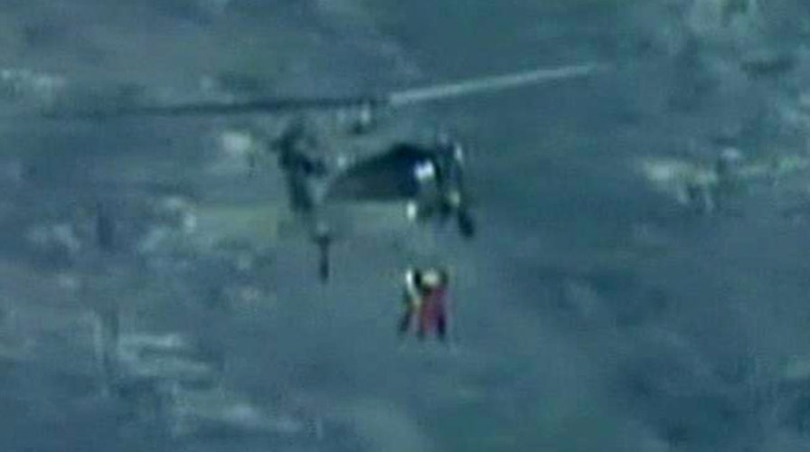 Rescuers rappel from helicopter to save climber