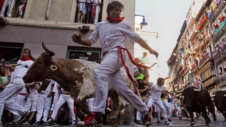 Bulls, thrill-seekers dash through streets of Pamplona