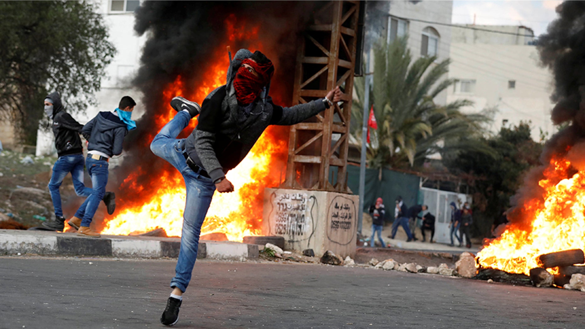 A Palestinian demonstrator hurls stones toward Israeli troops during clashes at a protest against U.S. President Donald Trump's decision to recognize Jerusalem as the capital of Israel, near the West Bank city of Nablus, December 29, 2017