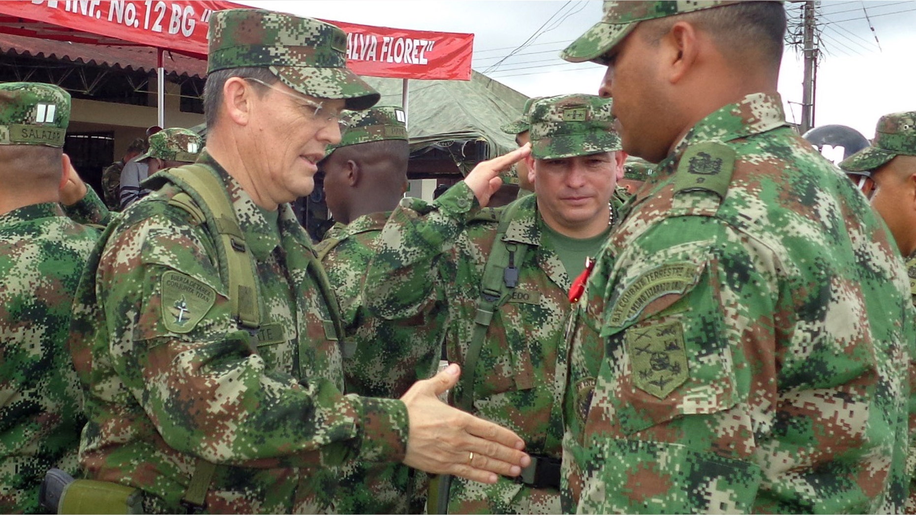 Colombian Army Gen. Ruben Dario Alzate, left, reaching to shake hands with a soldier in Bogota, Colombia.