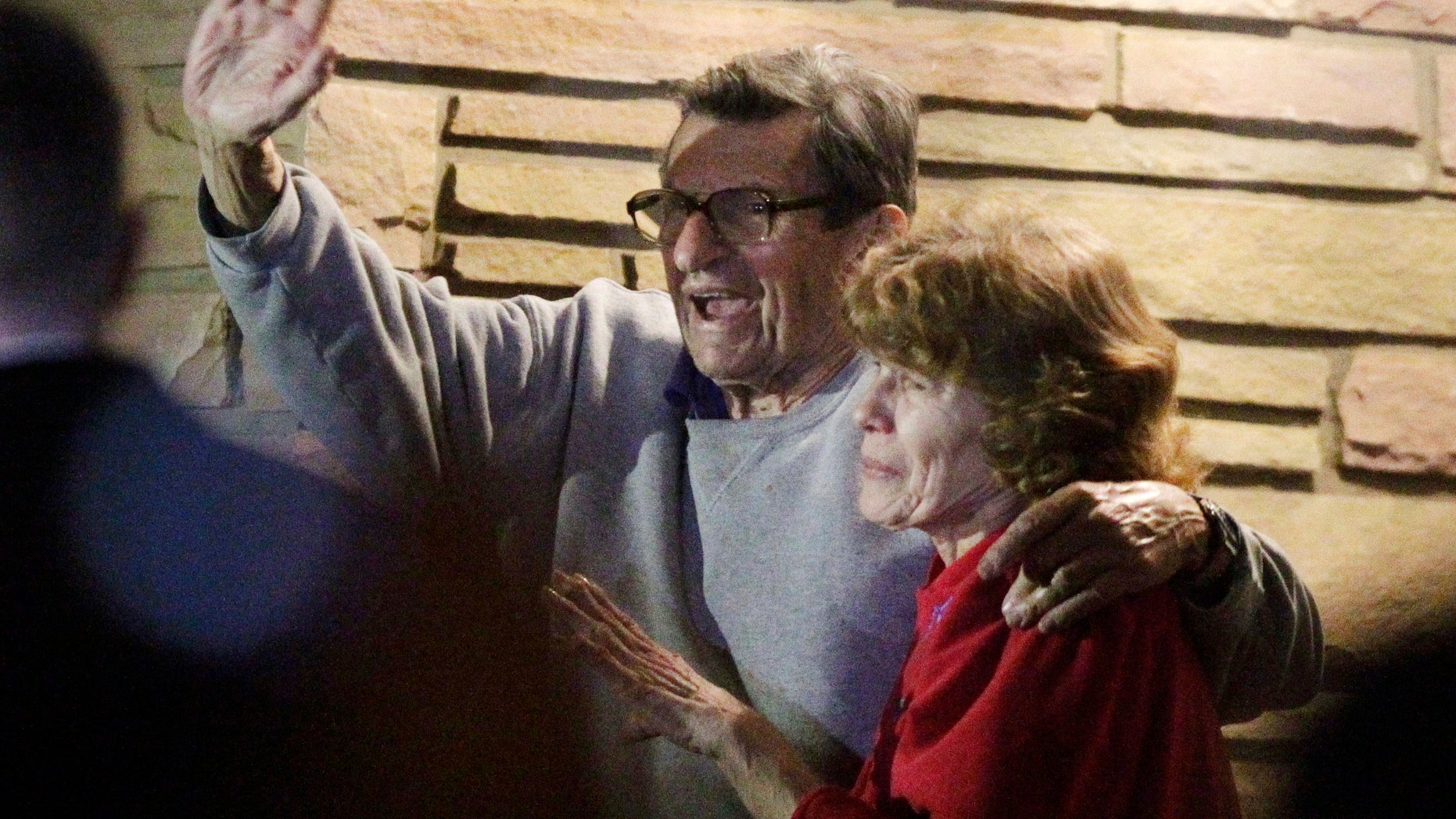 FILE - In this Nov. 9, 2011 file photo, former Penn State Coach Joe Paterno and his wife, Sue Paterno, stand on their porch to thank supporters gathered outside their home in State College, Pa. Sue Paterno says the family’s detailed response to a critical report on the handling of child abuse allegations against former assistant coach Jerry Sandusky is being released to the public. (AP Photo/Gene J. Puskar, File)