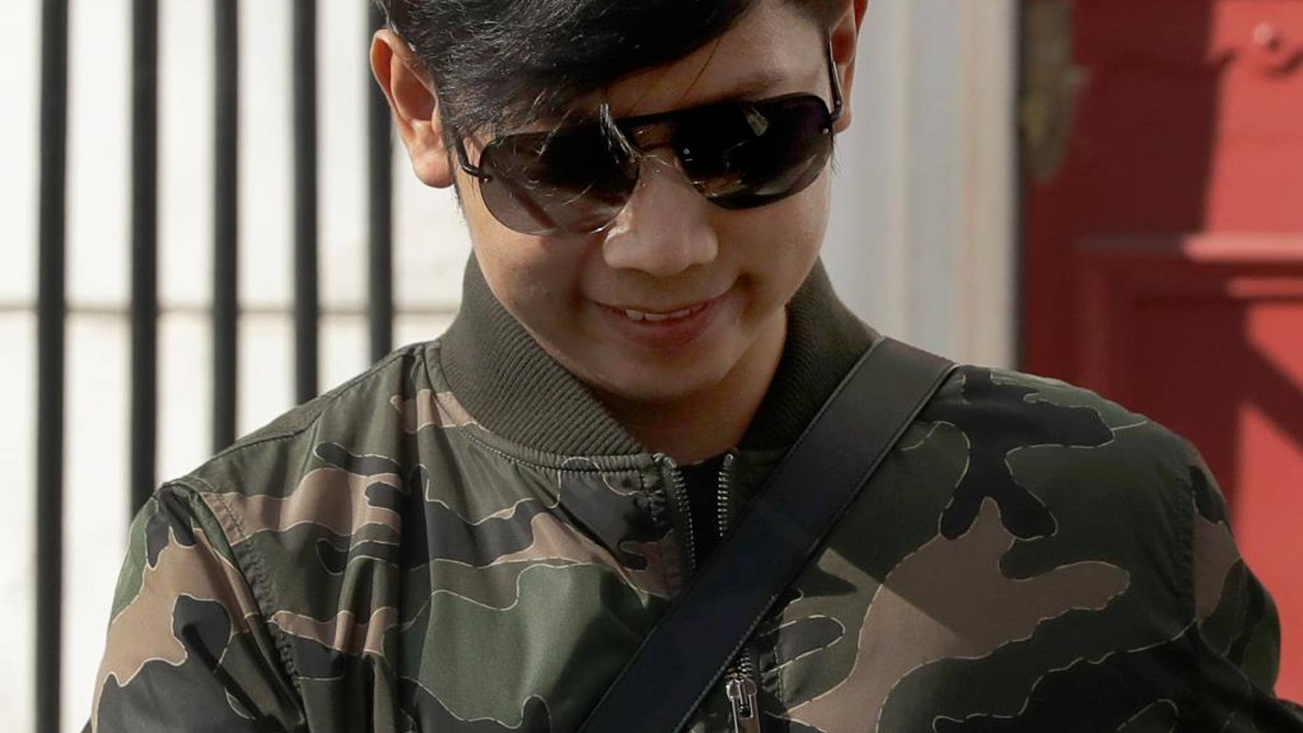 FILE - In this Wednesday, April 5, 2017, file photo, Vorayuth "Boss" Yoovidhya, whose grandfather co-founded energy drink company Red Bull, walks to get in a car as he leaves a house in London. Thailand's government has canceled the passport of the fugitive heir to the Red Bull energy drink fortune who is wanted on deadly hit-and-run charges, a Foreign Ministry official said Friday, May 5. (AP Photo/Matt Dunham, File)